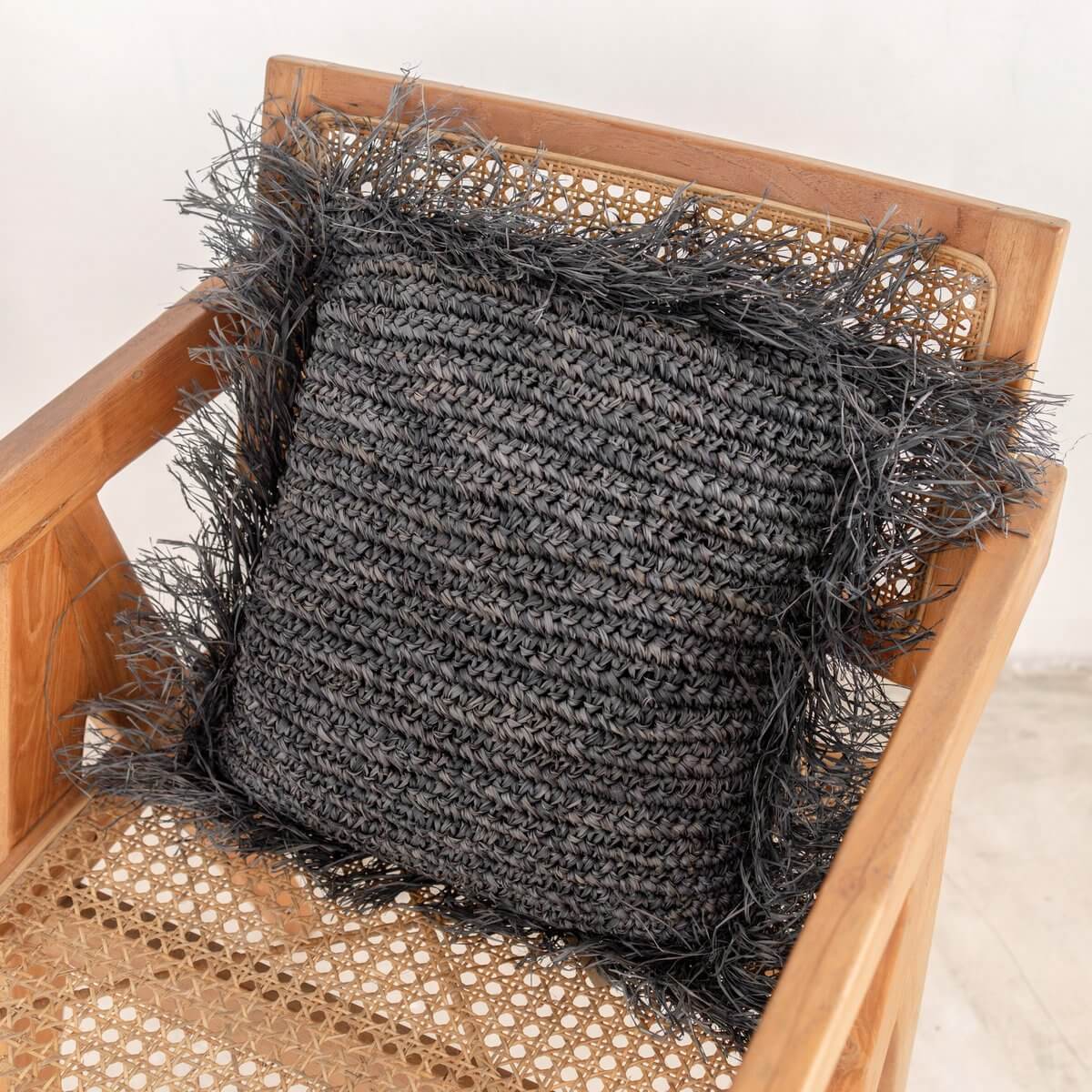 Alt Tag: Handgemaakt Sierkussen GANDI van Raffia op houten stoel, verkrijgbaar in maten 40x40 en 50x50 cm, plasticvrije verpakking
