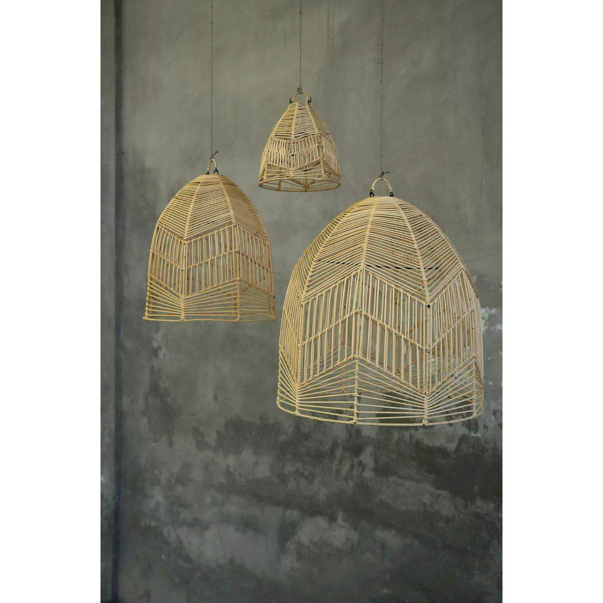 Drie handgemaakte rotan hanglampen Bala in natuurlijke kleur tegen een grijze muur, perfect voor boho inrichting van elke kamer.