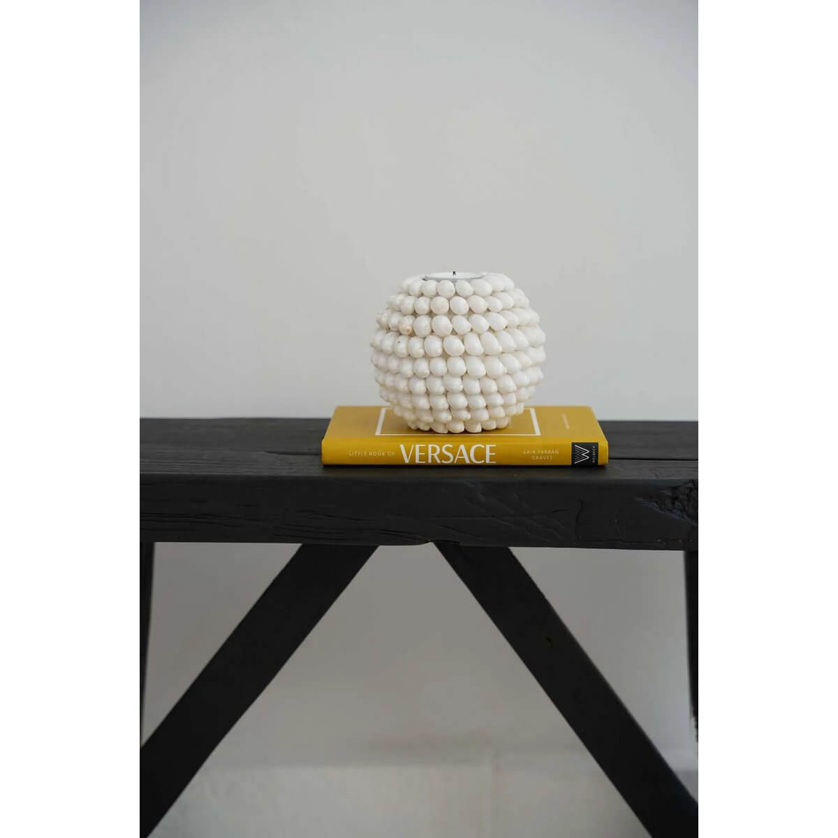 Bohemian Bubble Candle Holder with coastal shell design on display atop a Versace book, perfect for creating a cozy ambiance.