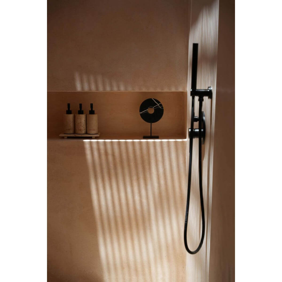 Marmeren schijf op zwarte standaard in moderne badkamer met flessen op plank