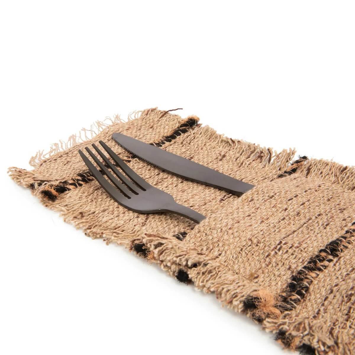 Bohemian-style beige bestekhouder with black fork and knife on woven fabric, adding luxury to dining. Handcrafted and unique.