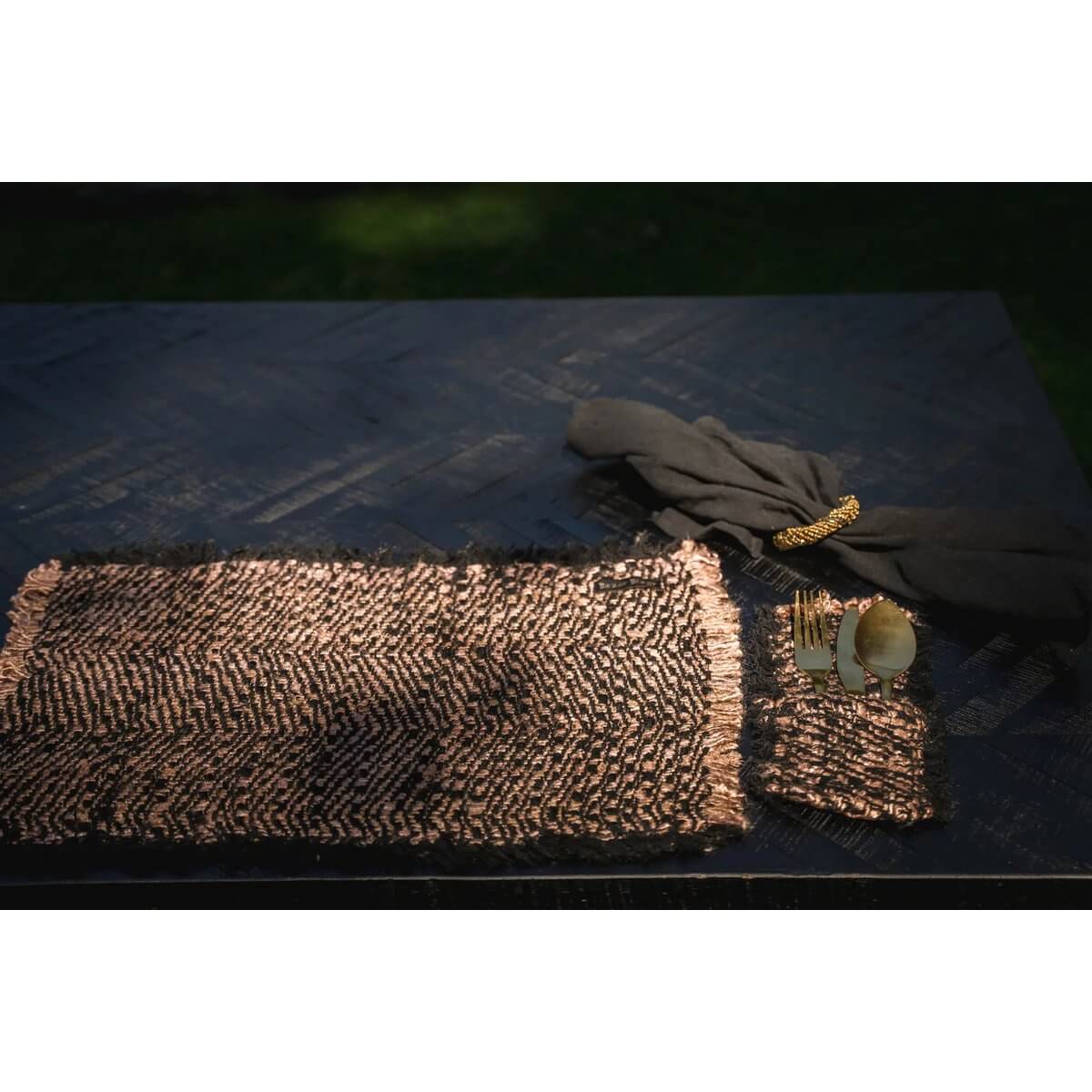 Luxurious Bohemian black and copper utensil holder set of 4 on an elegant table setting with matching placemats, perfect for dining.