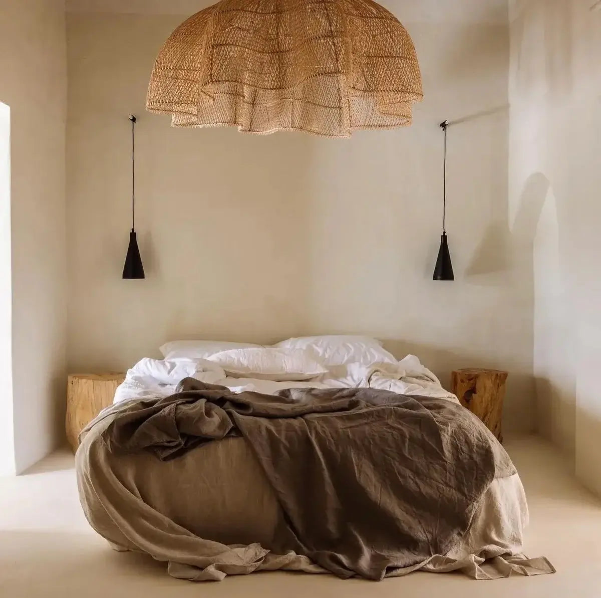 Rotan hanglamp The Whipped Hanger boven bed in bohemian slaapkamer met warme natuurlijke sfeer.