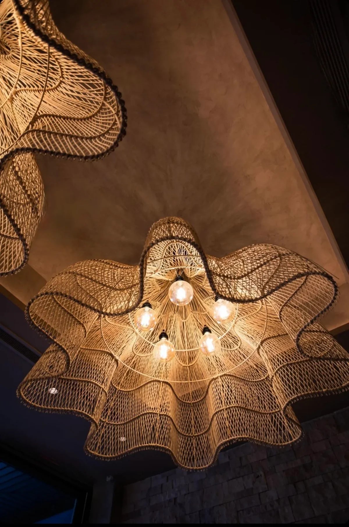 Rotan hanglamp The Whipped Hanger in bohemian stijl, verlicht en sierlijk gevlochten als blikvanger voor een boho-chique interieur.