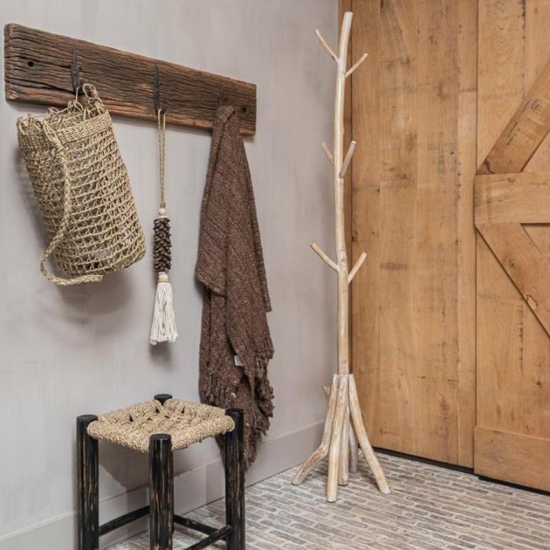 Naturel zeegras mand Julia in een rustieke hal met houten deur en accessoires.