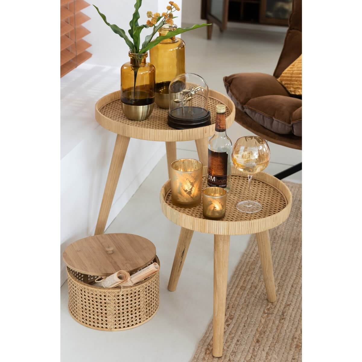 Gezellige woonkamer met bijzettafels, houten vloer en decoratieve accessoires in natuurlijke tinten.