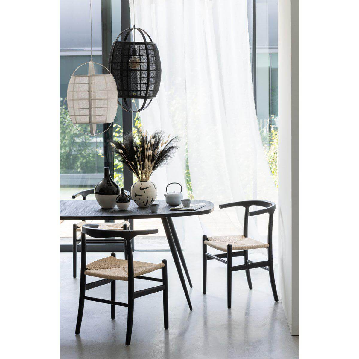 Moderne eetkamerset met J-Line Stoel Toon van beukenhout en zwart touw, naast ronde tafel en stijlvolle hanglampen.