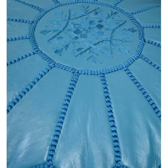 Detail van een turquoise Marokkaanse leren poef, handgemaakt met gedetailleerd borduurwerk, perfect voor boho interieur.