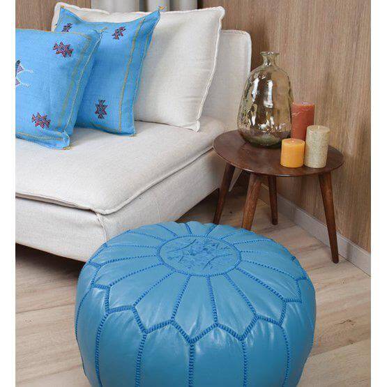 Turquoise leren poef in boho stijl in woonkamer, ideaal als voetenbankje of decoratie, handgemaakt Marokkaans design.