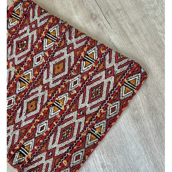 Close-up van een handgemaakt Marokkaans kussen P572 met kleurrijk vintage Berberpatroon, perfect voor woon- of slaapkamerdecor.