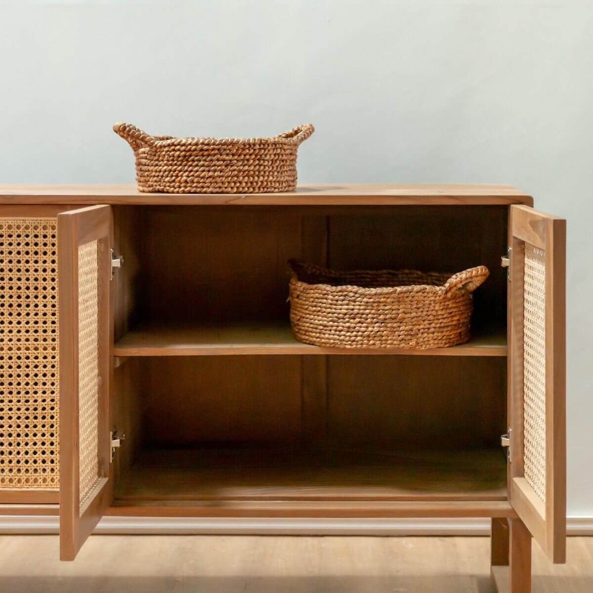 Twee opbergmanden JAWAH van waterhyacint op een houten kast, ideaal voor brood of fruit, handgemaakt en duurzaam.