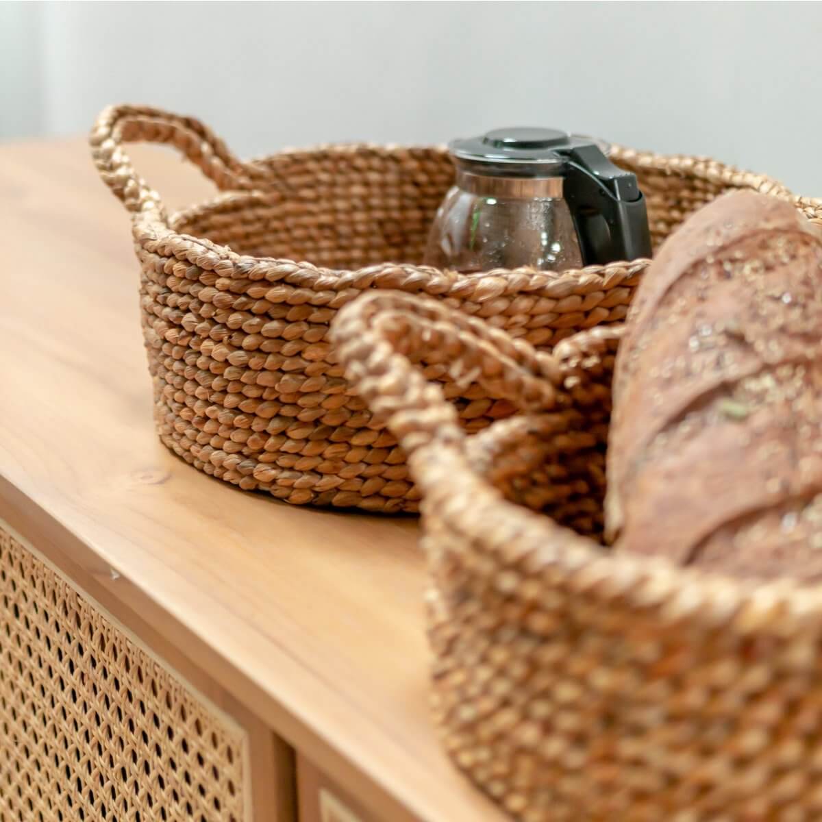 Waterhyacint opbergmand JAWAH met brood op tafel. Handgemaakt, duurzaam en ideaal als broodmand. Gratis verzending NL winkel.