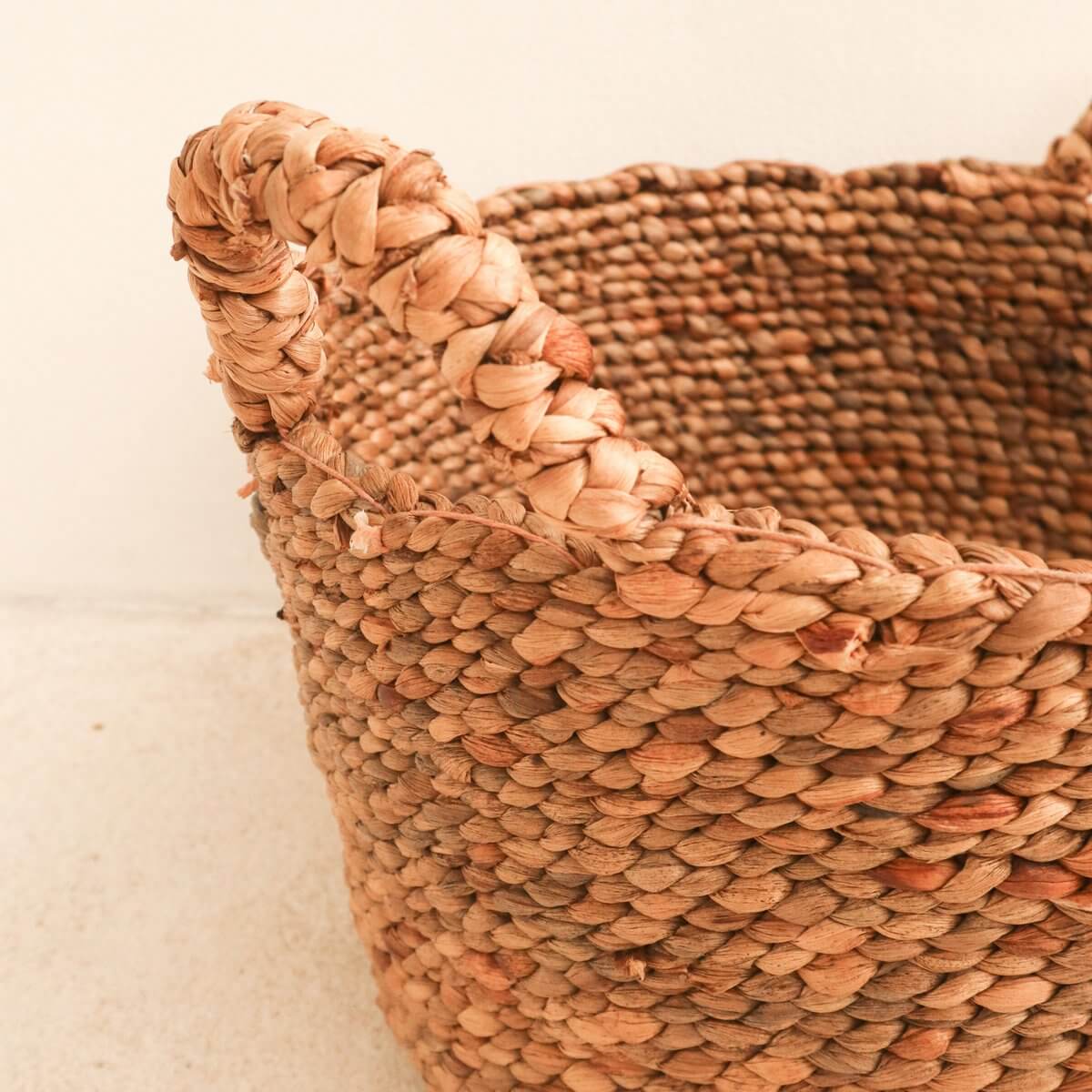 Alt Tag: Close-up van handgemaakte waterhyacint opbergmand SAMU met stevige gevlochten handgrepen, natuurlijke kleur en textuur.