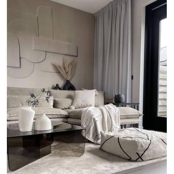 Stijlvolle woonkamer met Beni Ouarain vloerkussen, moderne grijze bank en elegant decor, ideaal voor een gezellige sfeer.