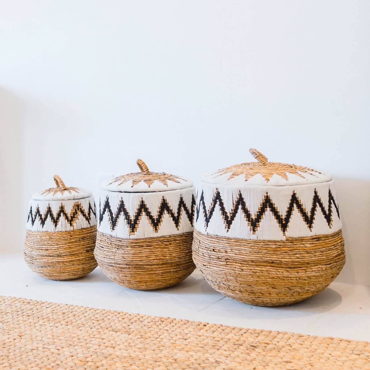 Drie boho wasmanden Palem met deksels in verschillende maten, handgemaakt van bananenvezels en katoenen stiksels.