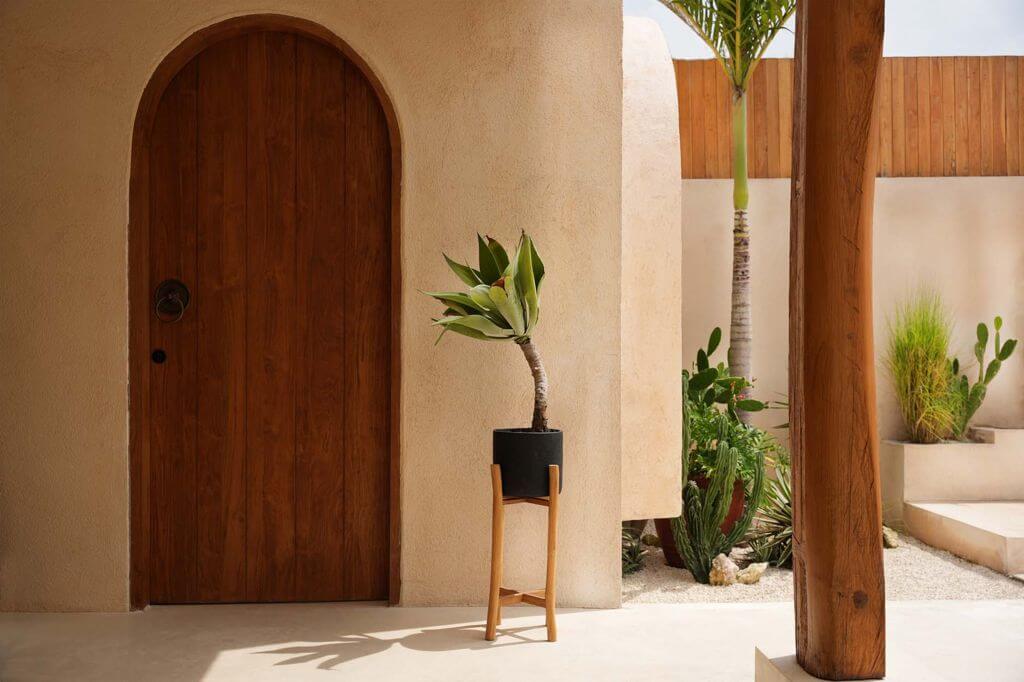 Rustieke patio met groene plant in teakhouten en terracotta Boho vaas The Chalk High L voor stijlvolle plantenopslag.