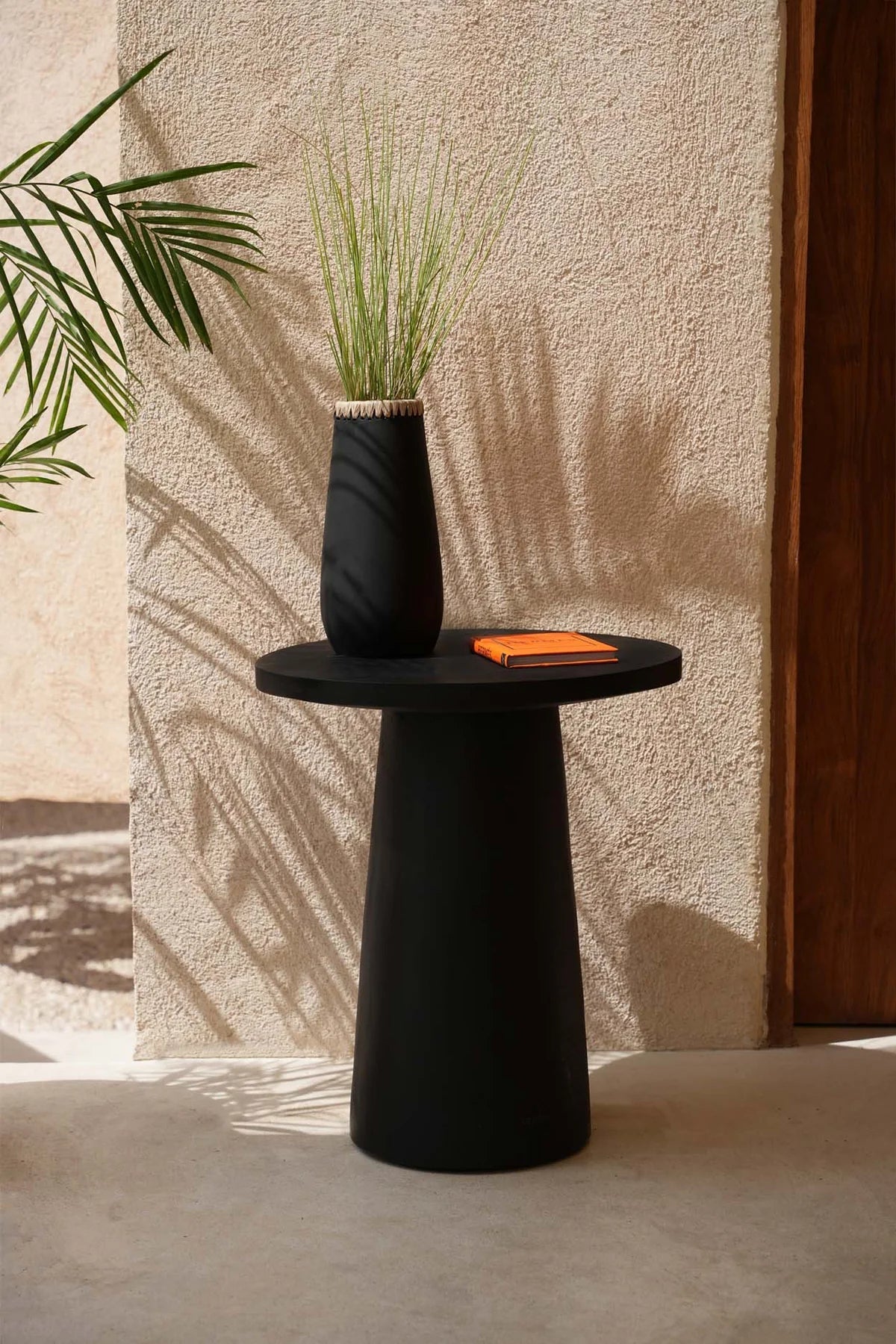 "Boho zwarte vaas The Sneaky L op ronde tafel, stijlvol en handgemaakt voor een modern industrieel interieur."