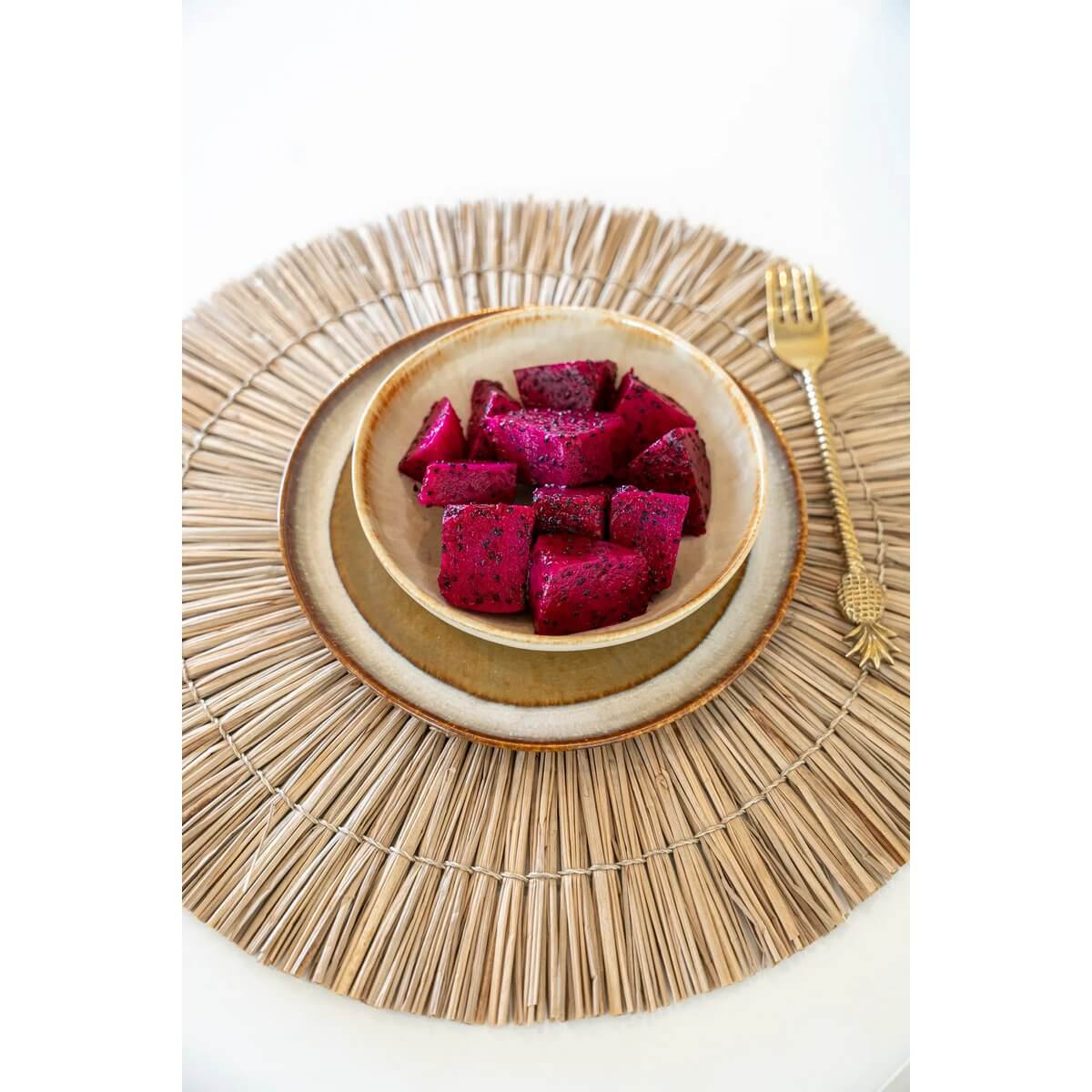 Bohemian-style round placemat in natural tones with a bowl of vibrant fruit, adding a chic boho touch to your table setting.
