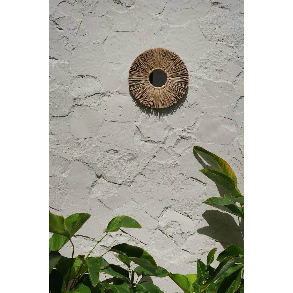 De Alang Alang spiegel in zeegras op een stenen muur, boho interieurdecoratie.