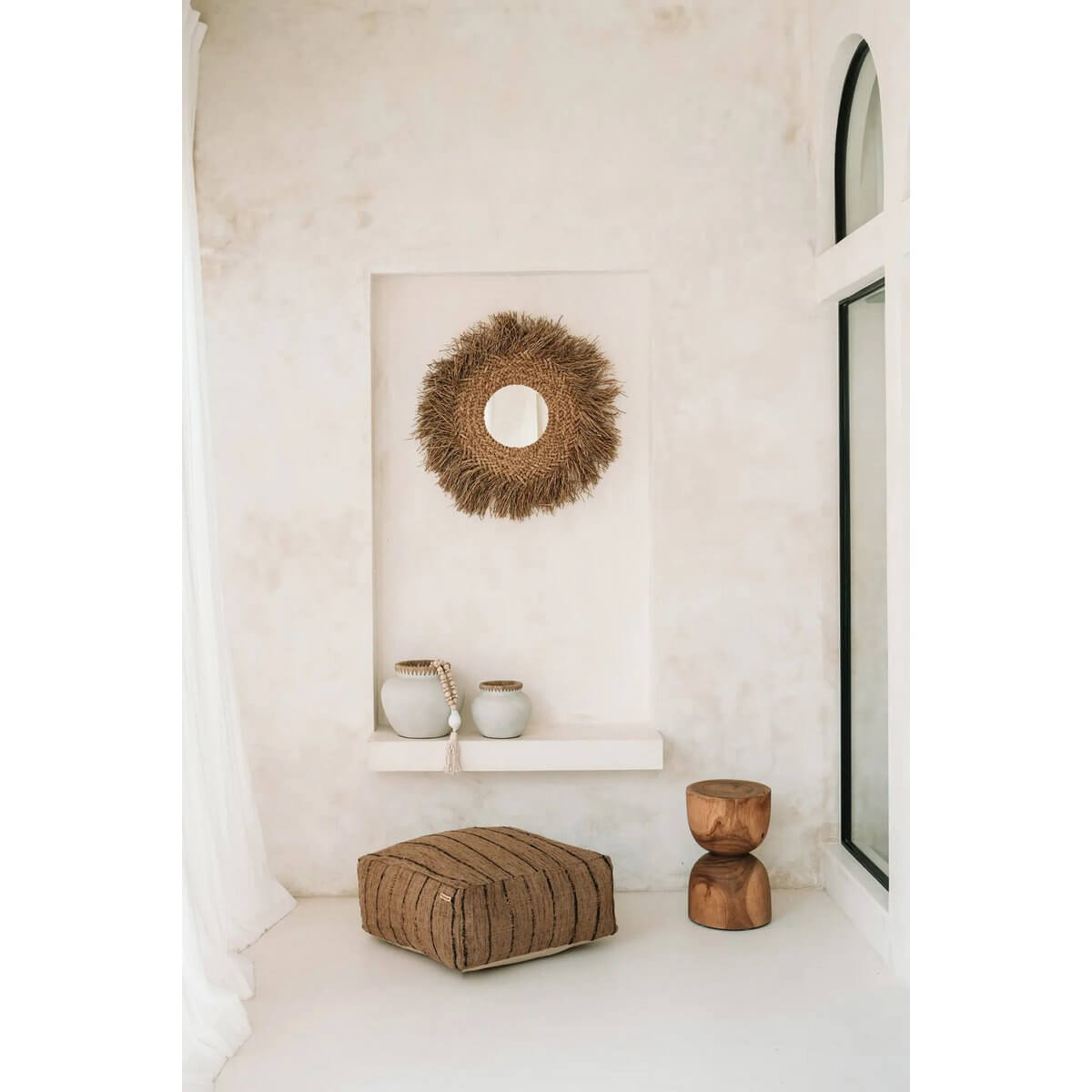 Bohemian-style room with an Azure kruk made of suarhout, featuring a woven wall decor, ceramic pots, and a cozy floor cushion.