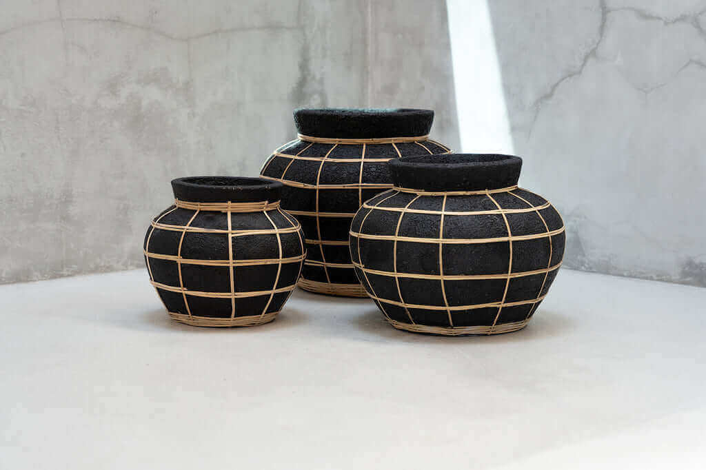 Drie terracotta De Belly vazen in zwart met rotan accent, geschikt voor droogbloemen. Perfect voor kustvibes in huiselijke ruimtes.