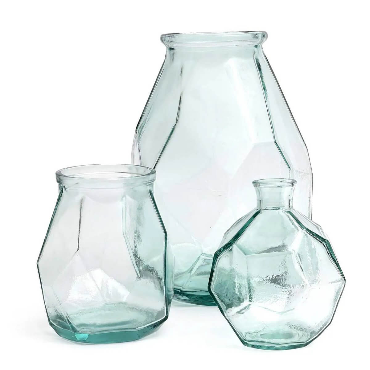 Three transparent, geometric glass vases with a bohemian style, showcasing an intricate origami-inspired design.