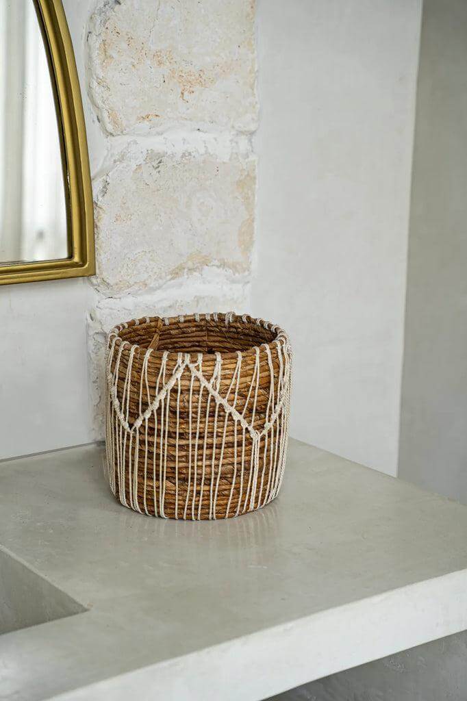 Handgemaakte macramé mand van bananenbladeren en katoen in natuurlijke kleuren, perfecte aanvulling voor een elegante woonruimte.