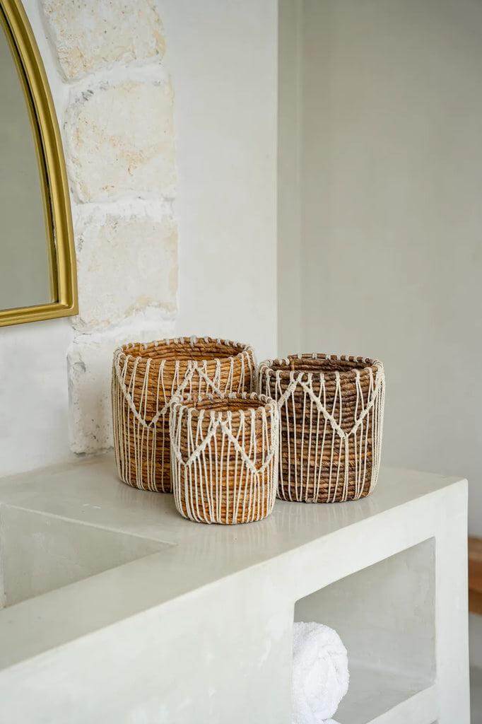 Set van drie handgemaakte manden in natuurlijke tinten met macramé ontwerp, perfect voor een vleugje elegante decoratie.