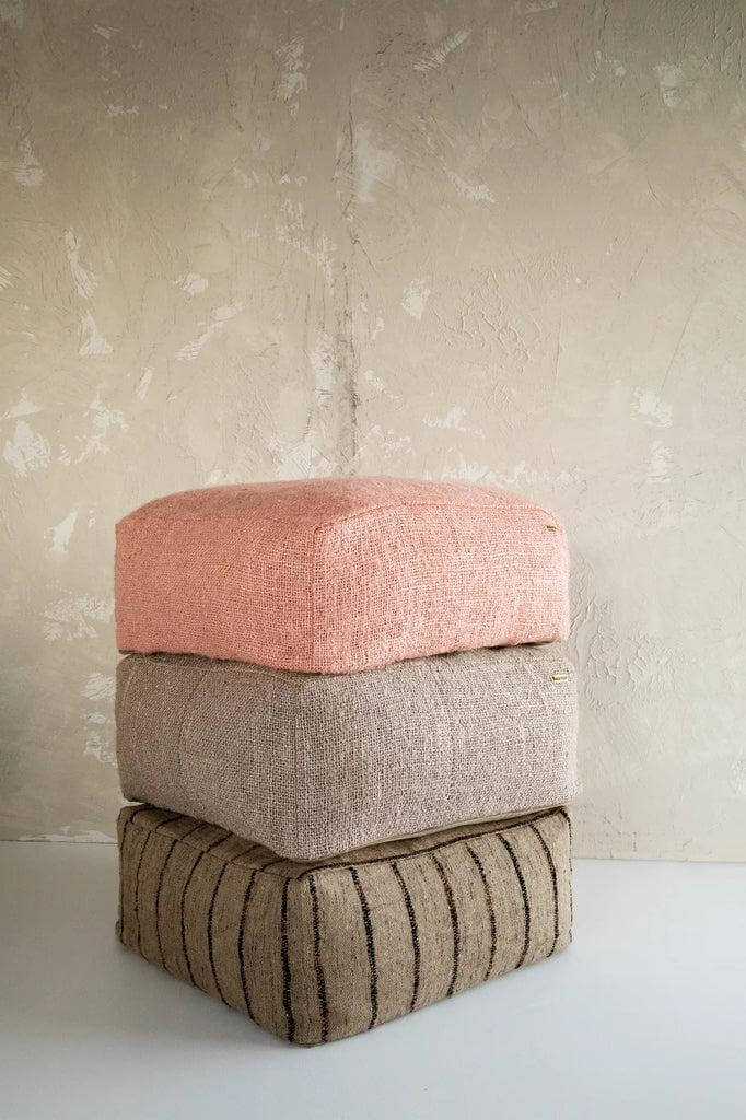 Stapel van drie katoenen poefs in zalmroze en neutrale tinten, ideaal als stijlvol zitaccessoire voor uw interieur of overdekte buitenruimte.