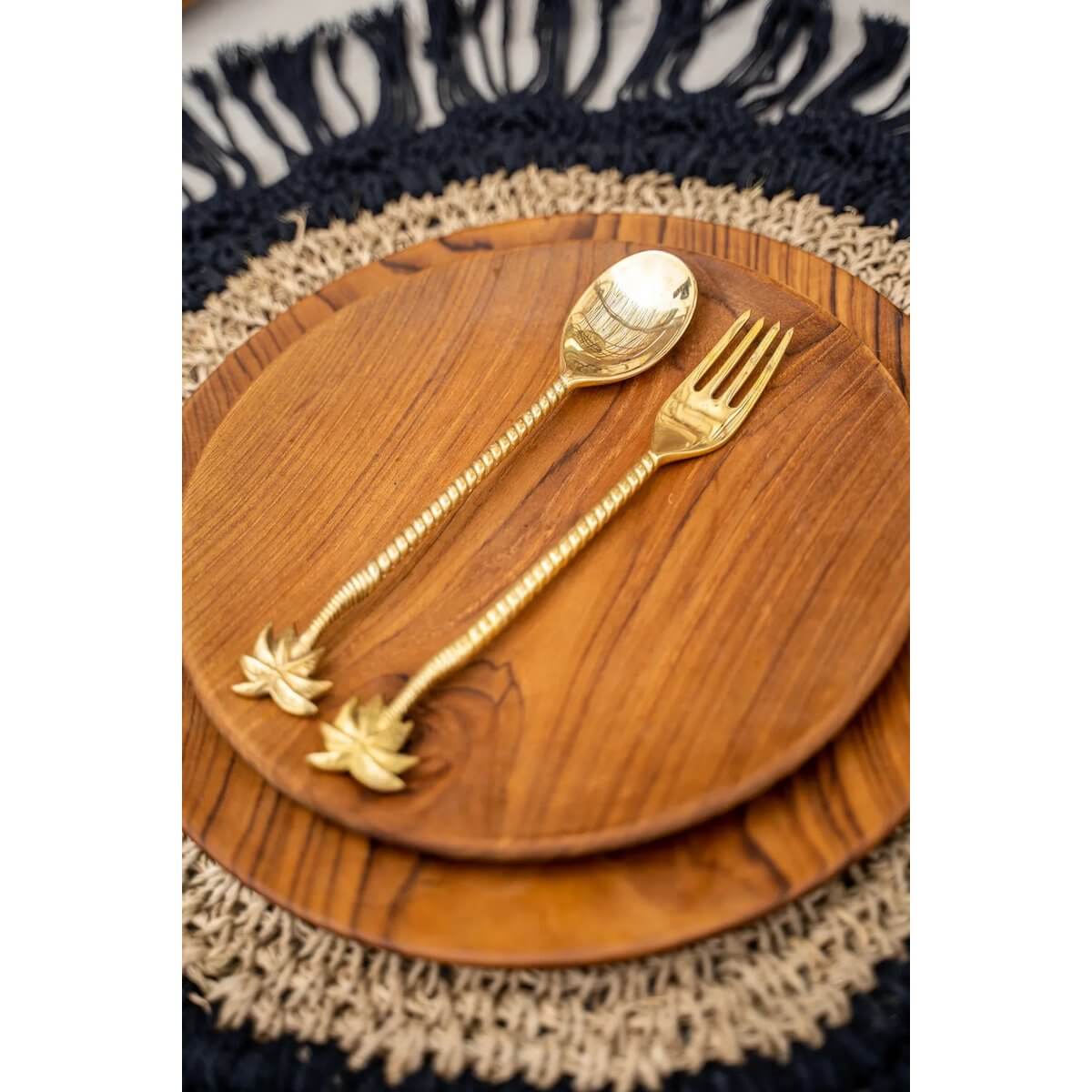 Gold palm tree spoon and fork set on a wooden plate, showcasing bohemian luxury with solid brass craftsmanship and tropical charm.