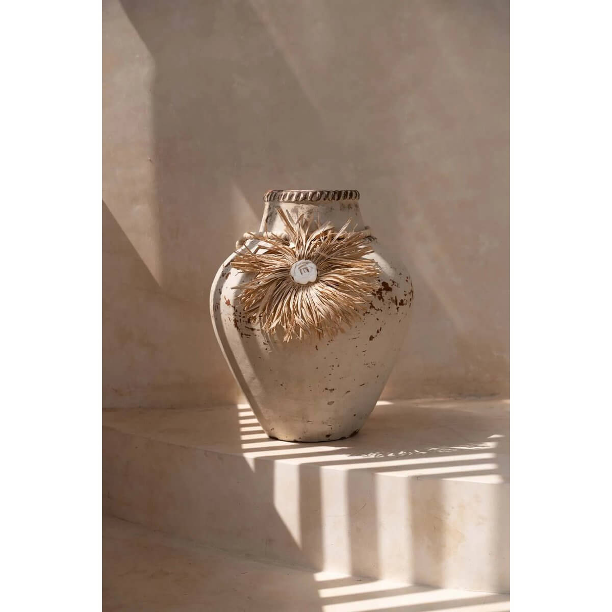 Bohemian style raffia tassel on a rustic vase, adds natural charm and elegance to any space.
