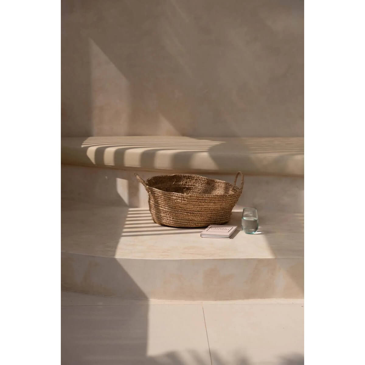 Bohemian Raffia basket on a sunlit shelf, perfect for small spaces, adding rustic charm and natural warmth to your decor.