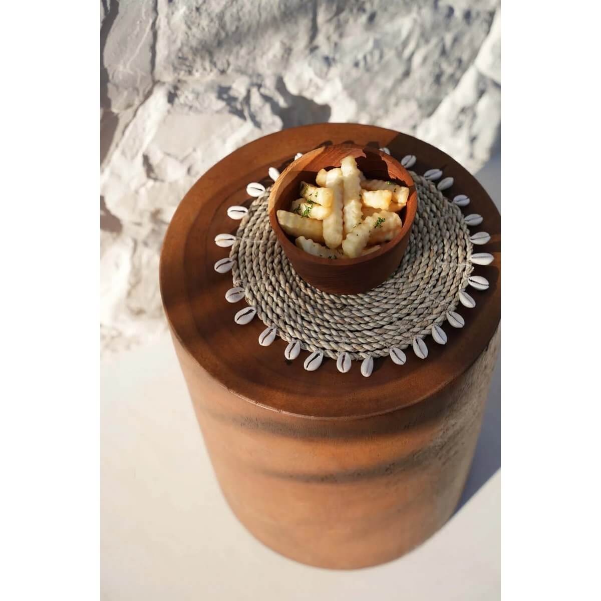 Stylish bohemian De Raffia Shell pan coaster with kauri shells, perfect for any table setup, adding an island touch. Diameter: 23cm.