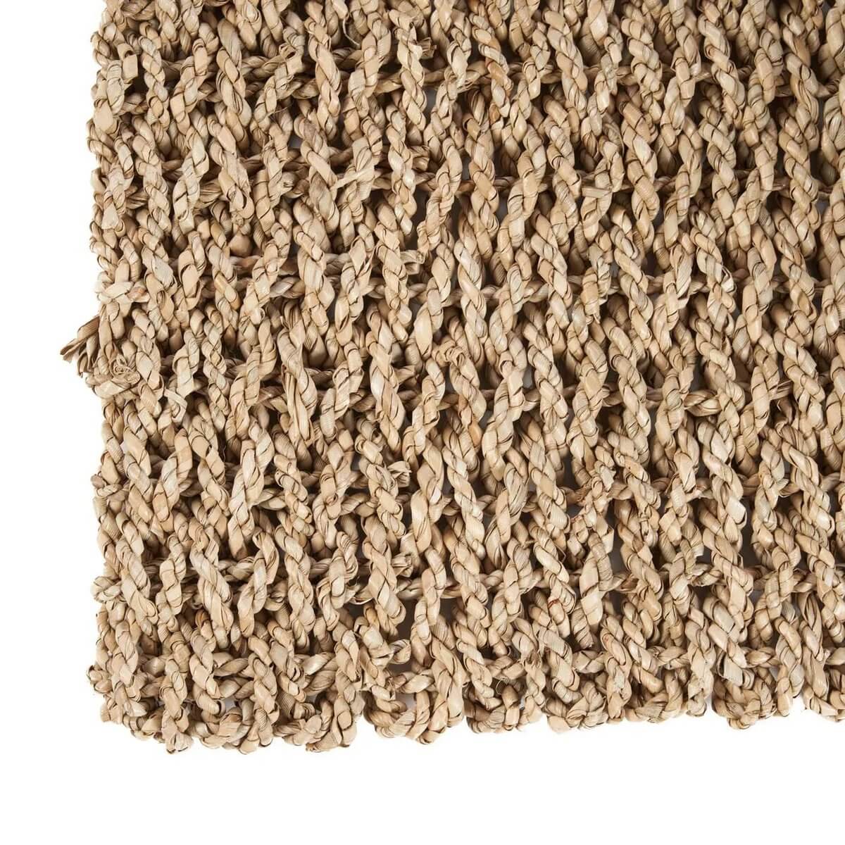 Close-up of natural sisal rug texture, showcasing woven design in earthy tones for bohemian style.