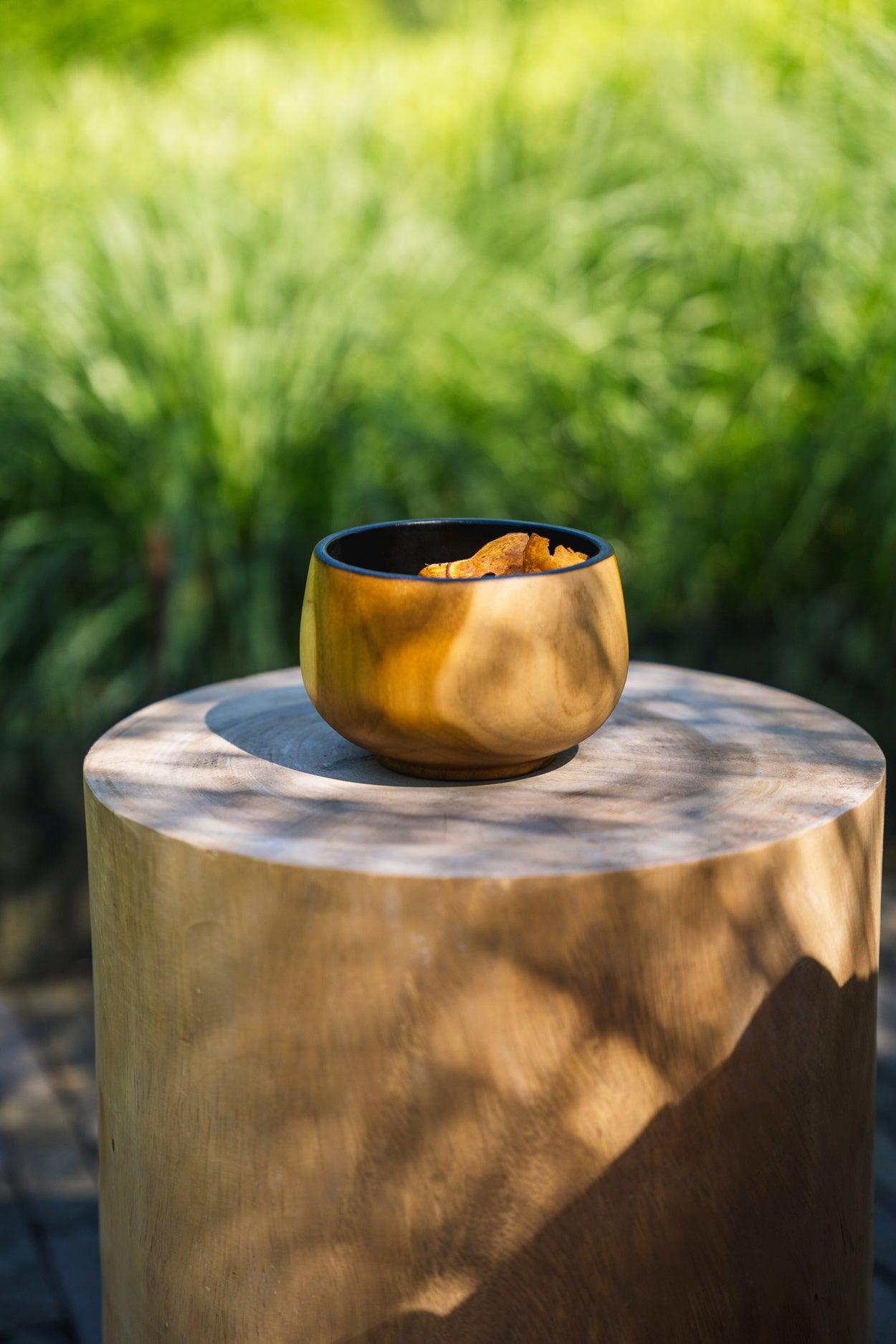 Massieve houten kruk met natuurschaal op zonnige dag, perfect voor binnen en buiten gebruik.