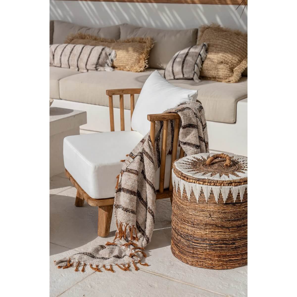 Elegant handgeweven bananenblad wasmand met bohemian uitstraling naast gezellige zithoek, ideaal voor modern of landelijk interieur.
