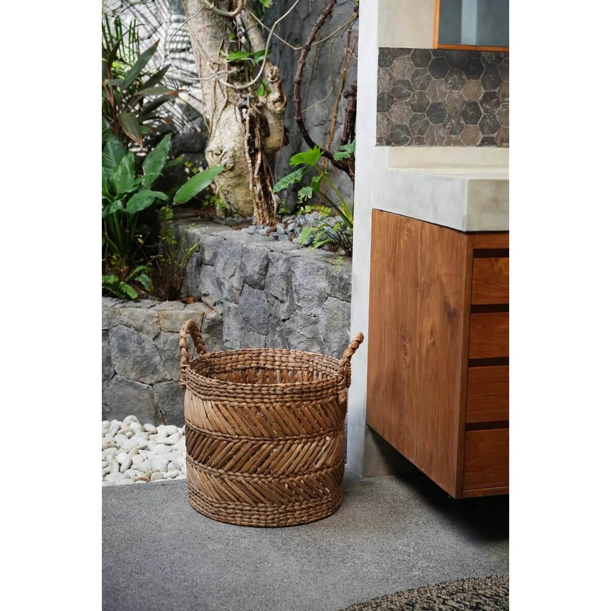 Een natuurlijke zigzag mand van gedroogde bananenbladeren, perfect voor opslag in een moderne woonkamer.