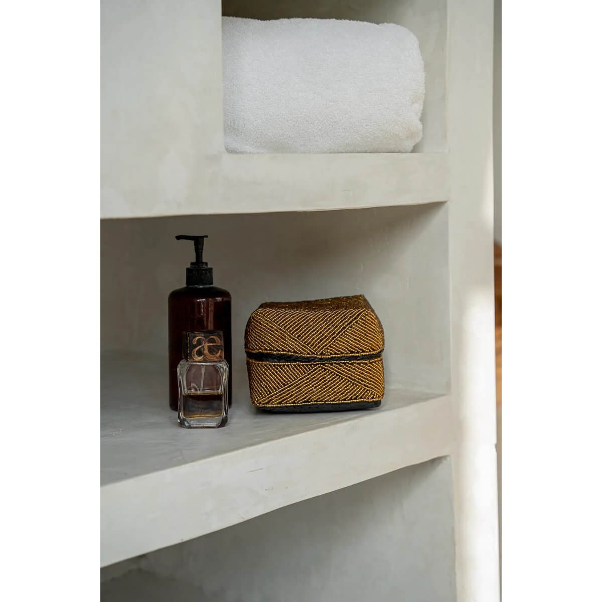 Handmade Bohemian gold bead box by Balinese artisans, perfect for home decor or storage, displayed on a shelf with toiletries.