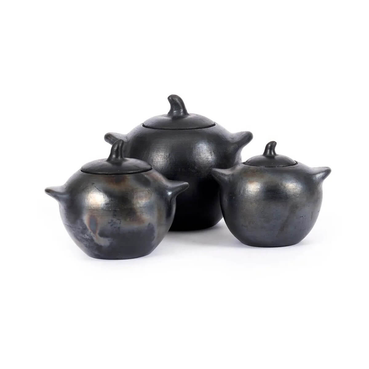 Three black-burnt pots from the Burned collection, perfect for a bohemian dining setup, available in three different sizes.