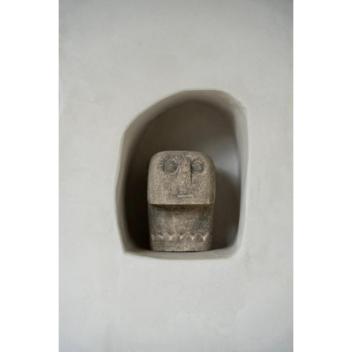 Hand-carved Sumba stone statue from Indonesia in a Bohemian style, nestled in a niche, offering protection and healing.