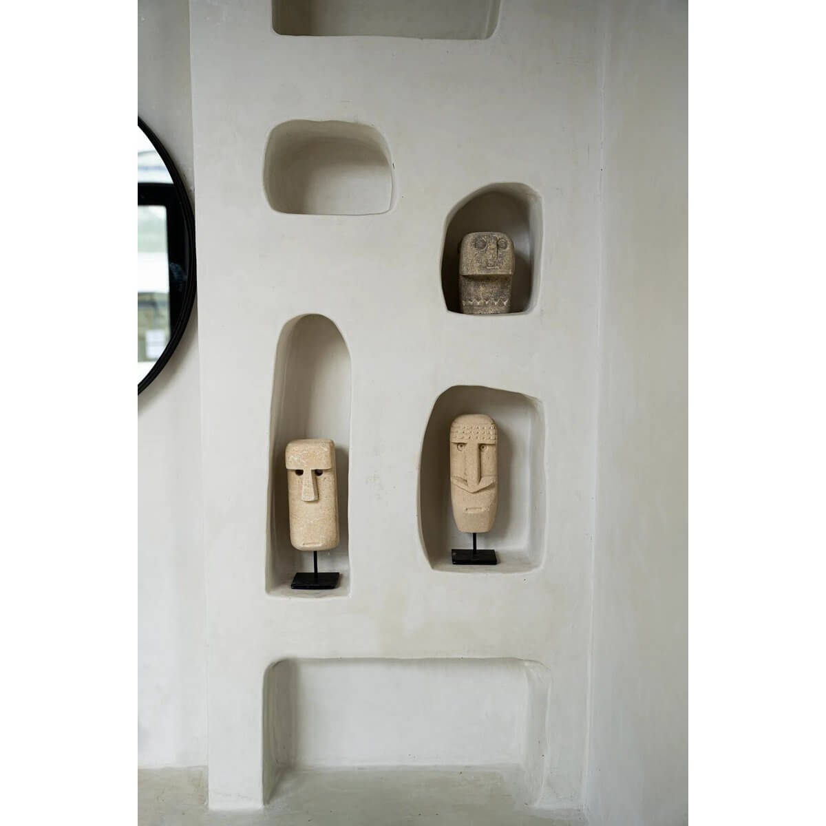 Bohemian Sumba stone statues on a shelf, handcrafted from sandstone by Indonesian artisans, offering protection and elegance.