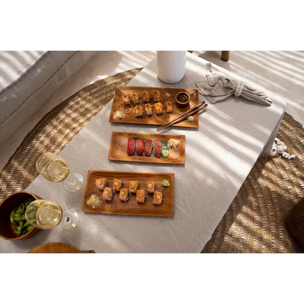 Linnen tafelkleed beige met sushi en wijnglazen, creëert een luxe eettafeelsetting.