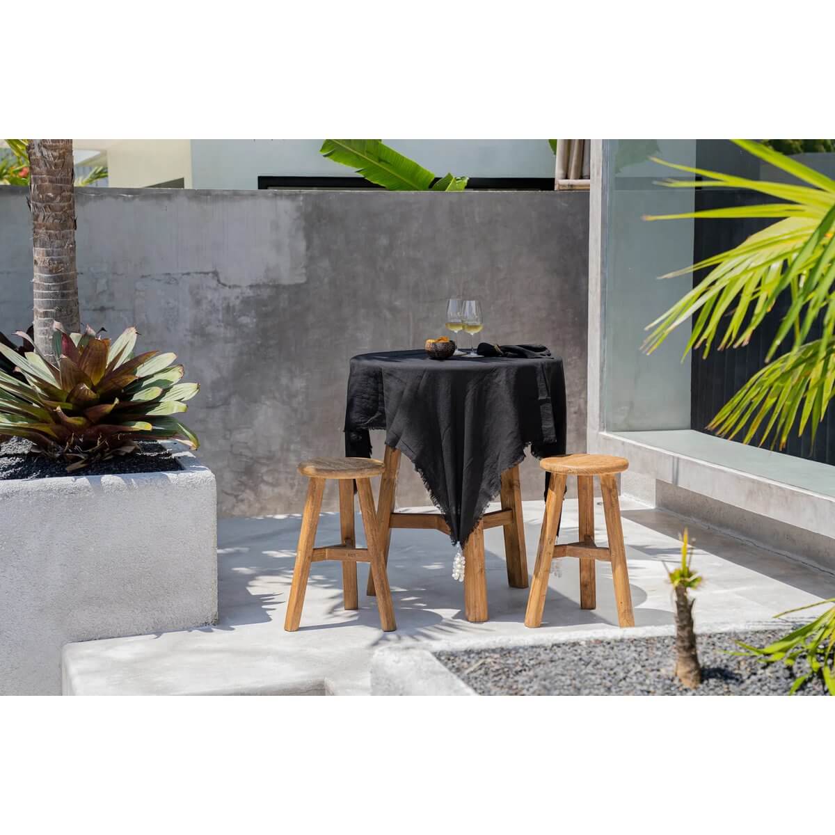 Zwart linnen tafelkleed van 150x150 cm op eettafel buiten, perfect voor stijlvolle tafeldecoratie.