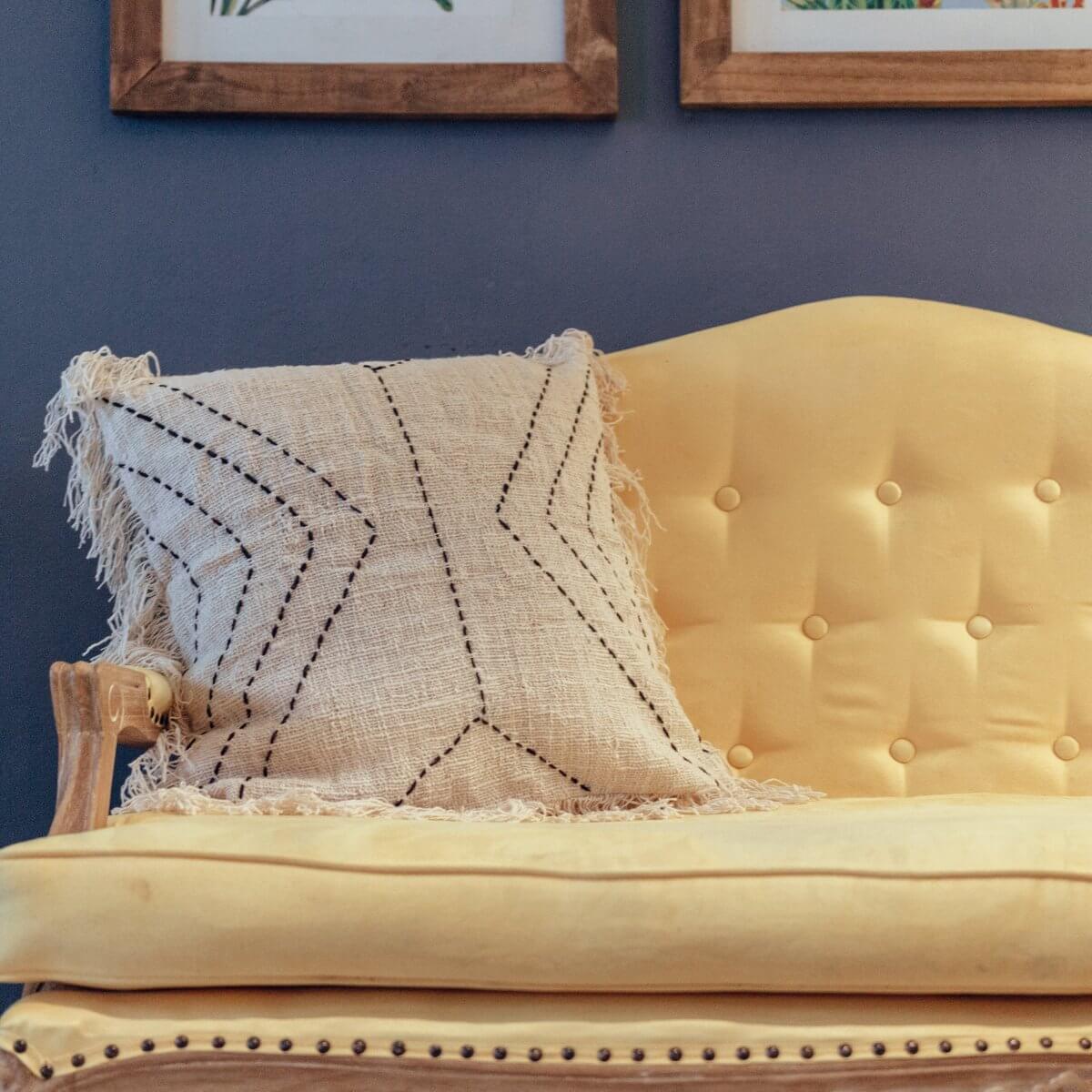 Bohemian cotton cushion with decorative pattern on yellow couch, available in 40x40 or 50x50 cm, handwoven and fair trade.