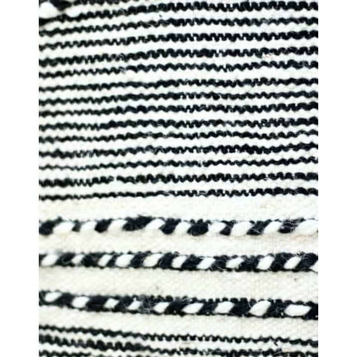 Detail van een zwart-wit gestreept Marokkaans vloerkussen Zanafi - uniek bohemian design met vintage berberstijl.
