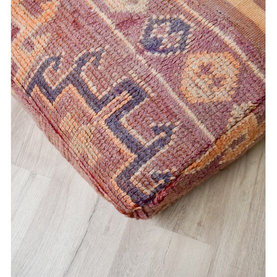 Marokkaans vloerkussen van vintage berberkleed met bohemian ontwerpen op houten vloer, unieke handgemaakte eyecatcher.