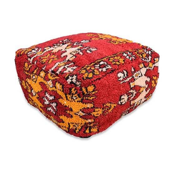 Marokkaans vloerkussen in bohemian stijl, gemaakt van vintage berberkleed, in levendige rood en gele patronen voor woon- of slaapkamer.