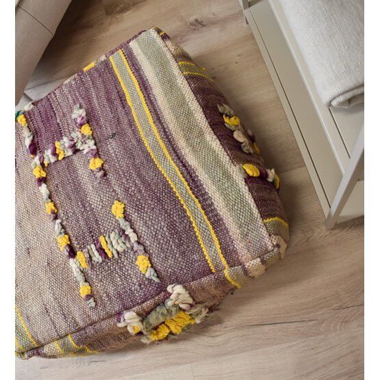 Uniek Marokkaans vloerkussen van vintage berberkleed in bohemian stijl, met kleurrijke strepen en franjes op houten vloer.