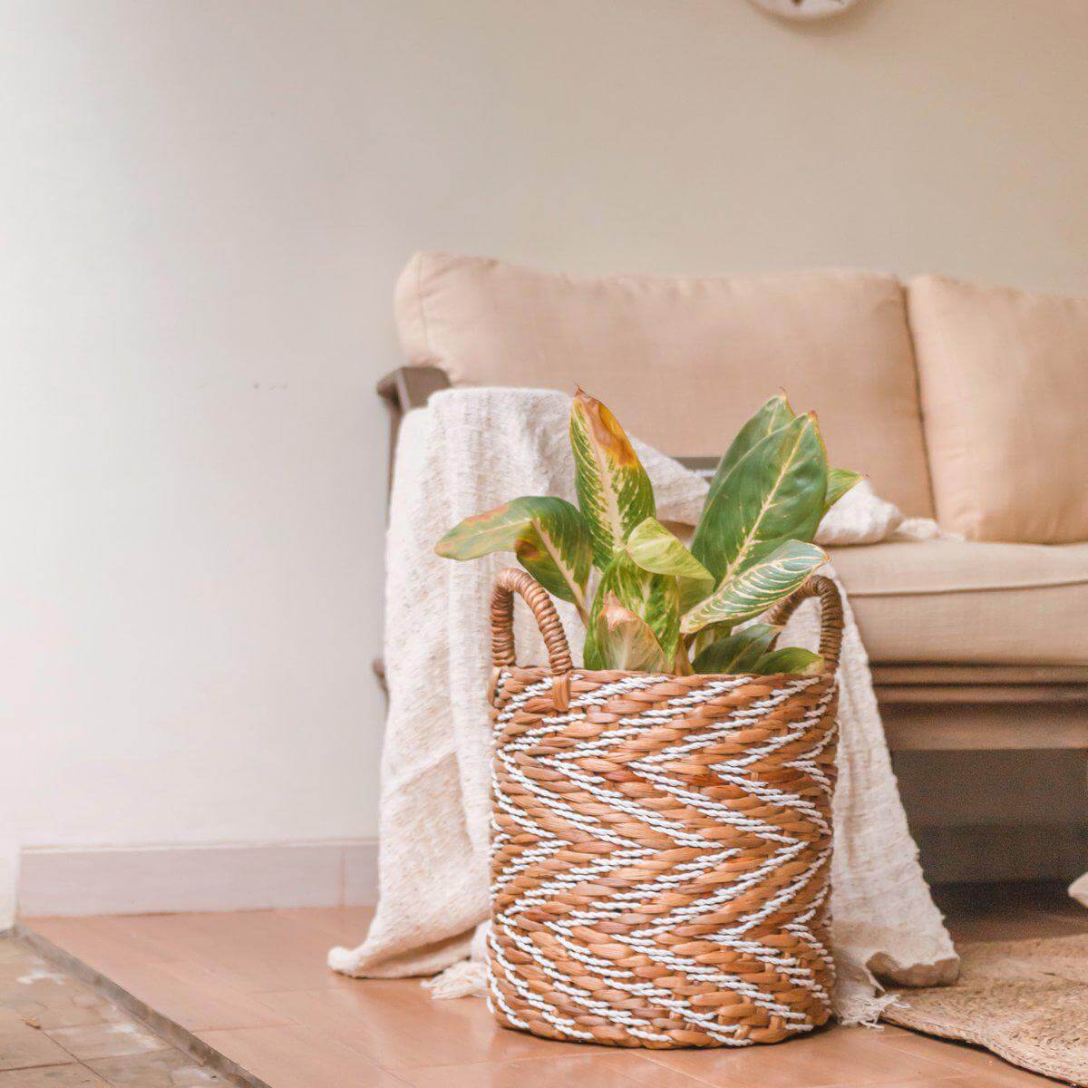 Alt Tag: Rond geweven mand YALIMO van waterhyacint met plant, strandhuisstijl, handvatten, naturel en wit, duurzaam en handgemaakt design.
