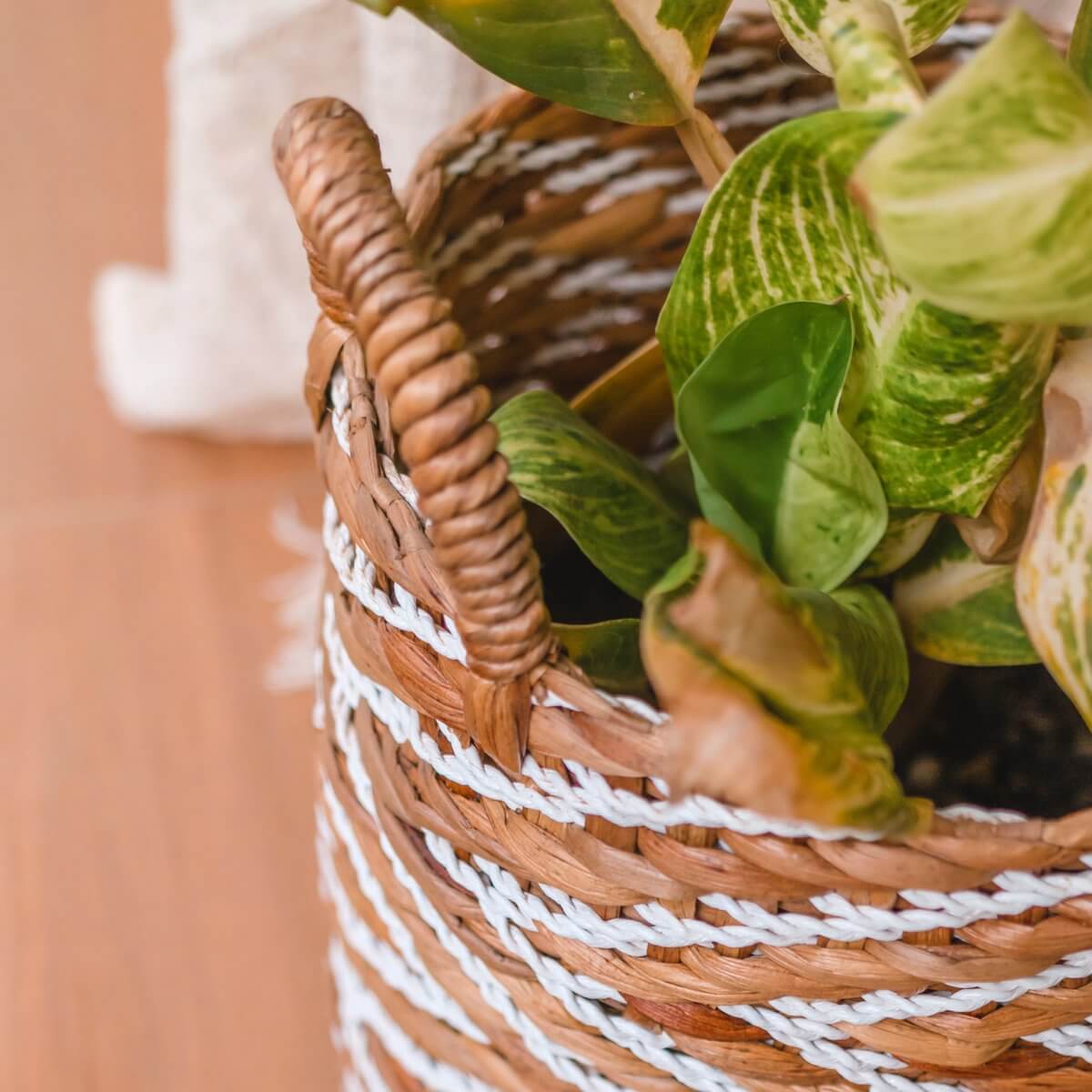 Gevlochten mand YALIMO van waterhyacint met plant; natuurlijke en witte strepen met handvat, duurzaam en handgemaakt.